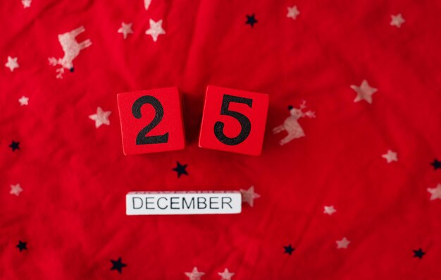 Le gros plan du 25 décembre est bordé de cubes rouges avec des lettres de décembre sur un noël rouge