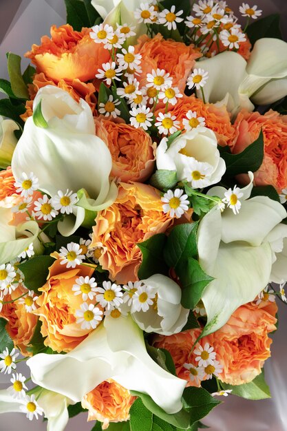 Gros plan du bouquet moderne de mode de différentes fleurs sur une surface en bois.