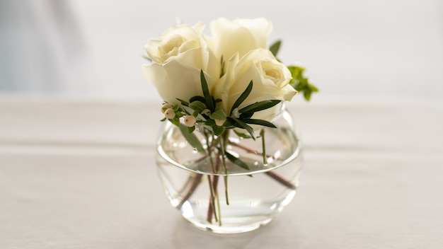 Gros plan du bouquet de roses blanches dans le bol en verre isolé