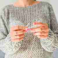 Photo gratuite gros plan du crochet d'une main de femme avec du fil rose