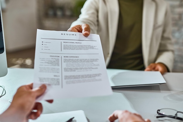 Photo gratuite gros plan du demandeur d'emploi donnant son cv lors d'un entretien d'embauche au bureau