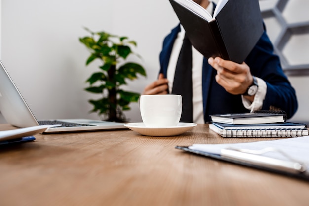 Gros plan du jeune homme d'affaires prospère sur le lieu de travail.