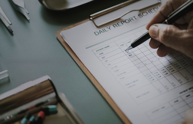 Photo gratuite gros plan du médecin vérifiant la liste de contrôle du rapport quotidien du patient