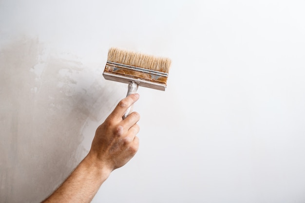 Gros plan du mur de peinture à la main avec une brosse.