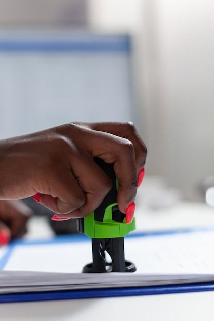 Photo gratuite gros plan du papier d'estampage à la main d'un médecin afro-américain avec prescription médicale au bureau de l'hôpital. médecin thérapeute expliquant le traitement médicamenteux à une femme âgée pendant la consultation