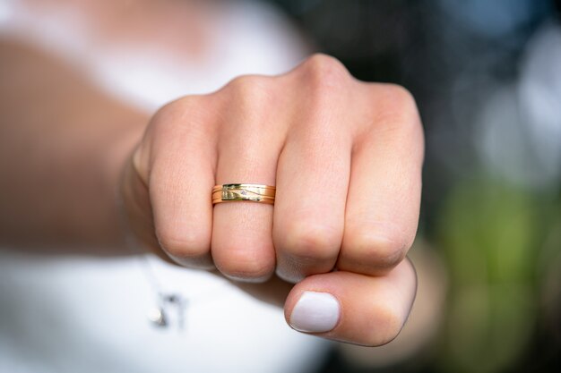 Gros plan du poing d'une femme avec une bague de mariage sur son annulaire