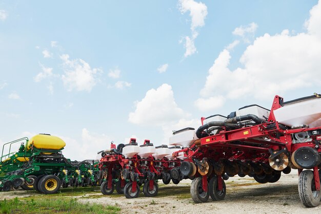 Gros plan du semoir attaché au tracteur dans le champ.