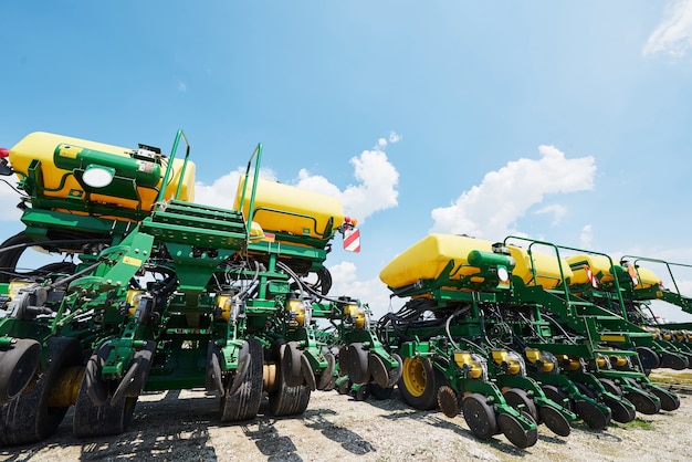 Gros plan du semoir attaché au tracteur dans le champ.