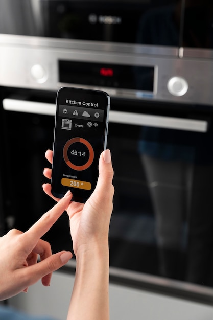 Photo gratuite gros plan du téléphone avec contrôle de la cuisine