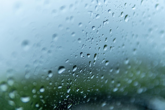 Gros plan du verre d'une fenêtre couverte de gouttelettes de pluie - pour les arrière-plans et les textures