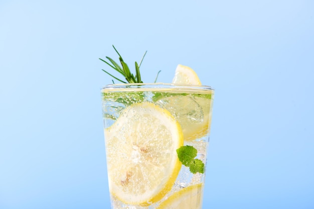 Photo gratuite gros plan d'eau de citron fraîche dans un verre avec des tranches de citron fruits isolés sur fond bleu