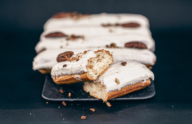 Gros plan d'éclairs en glaçure blanche aux noix de pécan