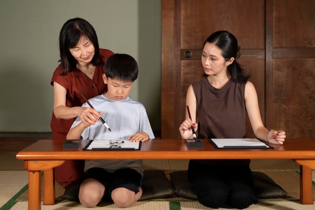 Gros plan sur des élèves faisant de la calligraphie japonaise, appelée shodo