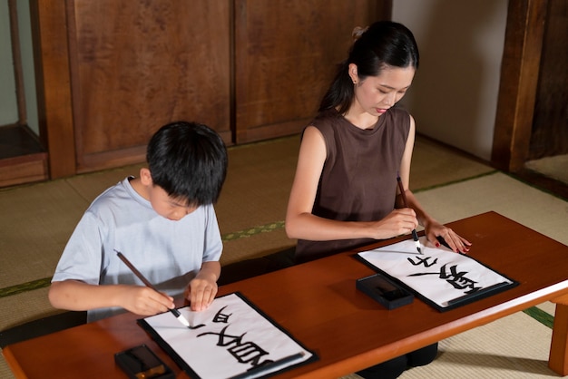 Photo gratuite gros plan sur des élèves faisant de la calligraphie japonaise, appelée shodo