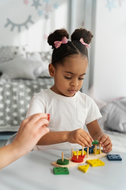 Gros plan sur un enfant appréciant un jeu didactique