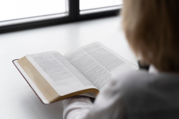 Gros plan enfant flou lisant la bible