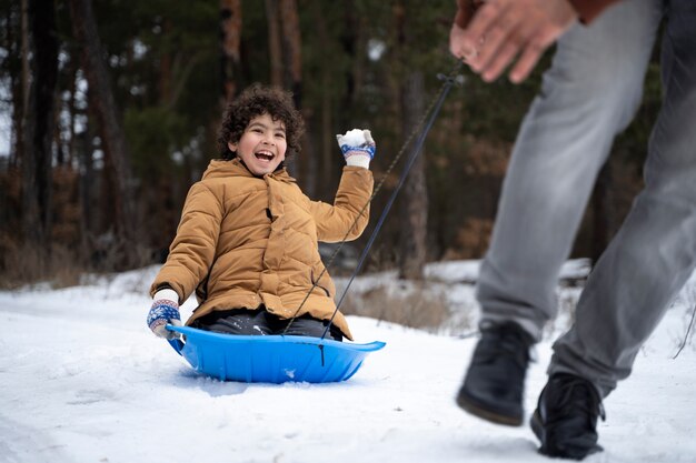 Gros plan sur un enfant heureux qui s'amuse avec la neige