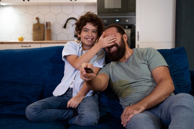 Gros plan sur un enfant qui regarde des films avec ses parents