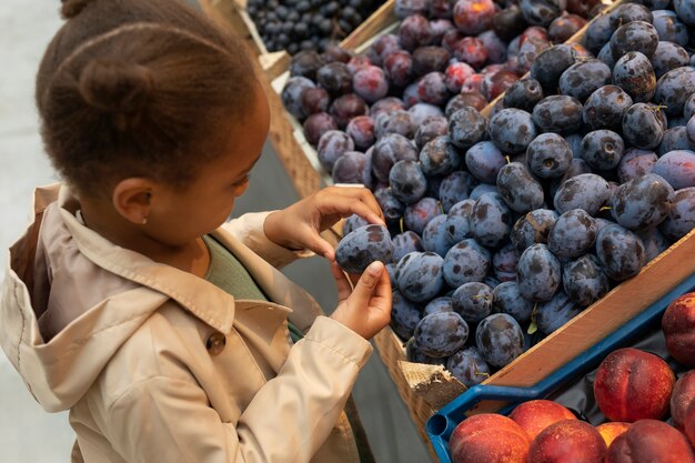 Gros plan enfant tenant des fruits