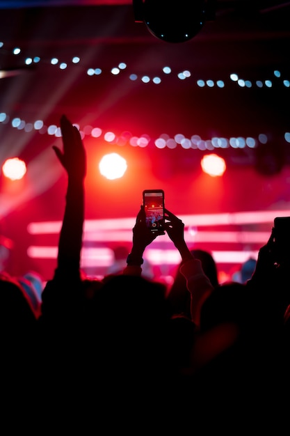 Photo gratuite gros plan d'enregistrement vidéo avec smartphone lors d'un concert. image tonique