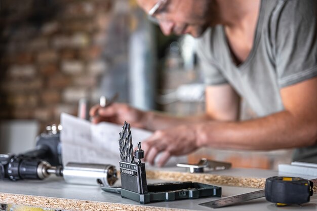 Gros plan d'un ensemble de perceuses à bois sur une table de travail d'un menuisier dans un atelier.