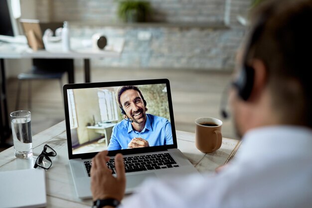 Gros plan d'un entrepreneur heureux ayant une vidéoconférence avec son collègue