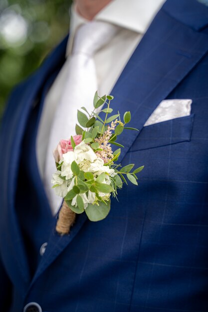 Gros plan d'un époux avec un costume bleu lors d'un mariage