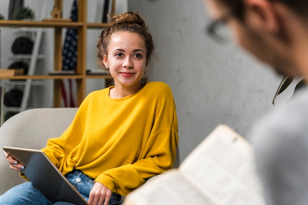 Gros plan des étudiants avec livre et tablette à l'intérieur