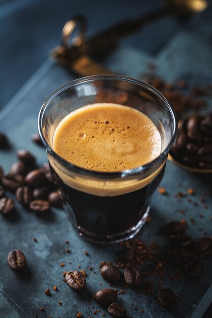 Gros plan d'un expresso frais classique servi sur une surface sombre.