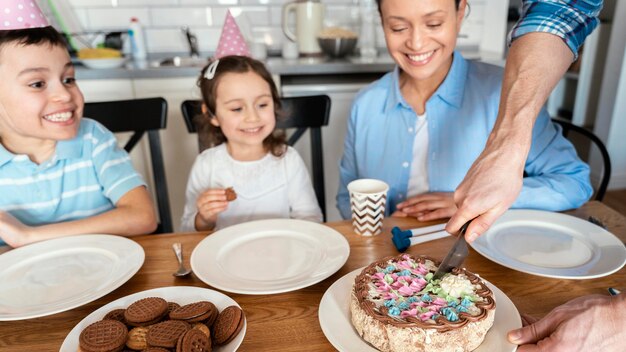 Gros plan de la famille célébrant avec un gâteau