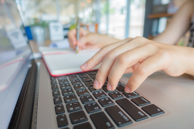 Photo gratuite gros plan de femme d'affaires en tapant des mains sur un clavier d'ordinateur portable.