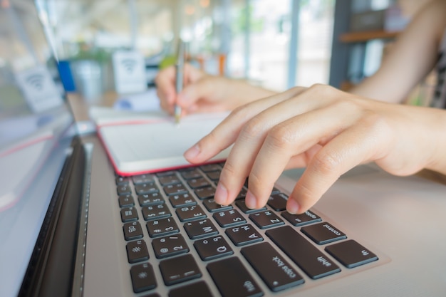 Gros plan de femme d&#39;affaires en tapant des mains sur un clavier d&#39;ordinateur portable.