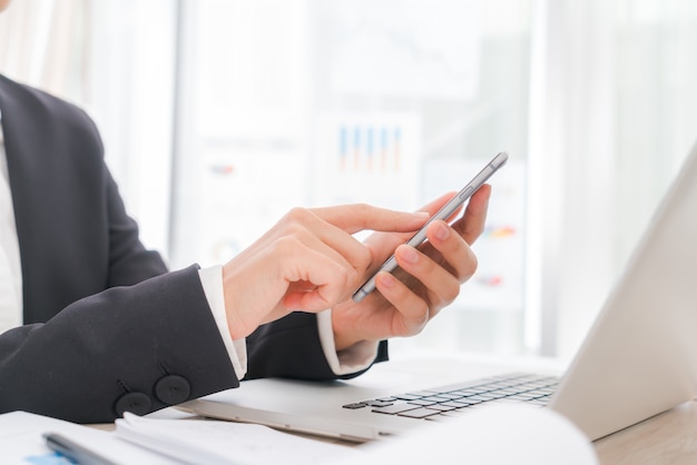 Gros plan de femme d&#39;affaires en tapant des mains sur un ordinateur portable clavier avec m