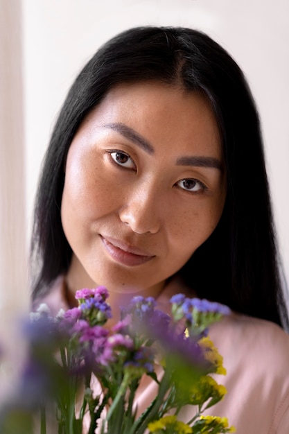 Photo gratuite gros plan femme d'âge moyen tenant des fleurs