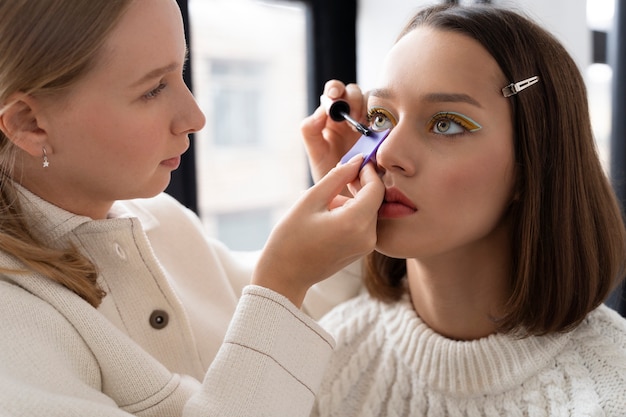 Gros plan femme appliquant du mascara