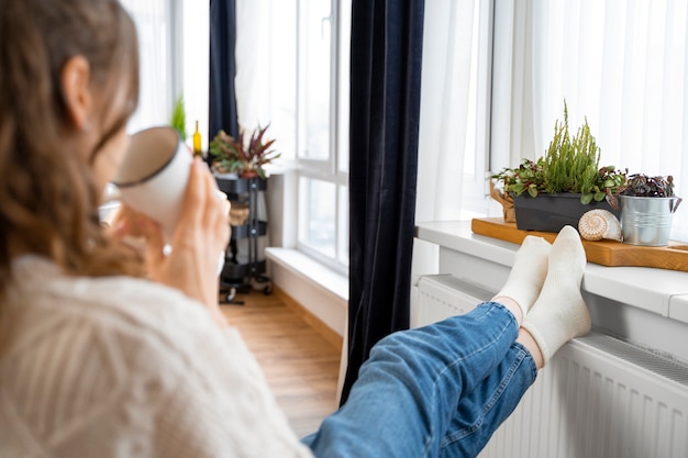 Gros plan femme assise près de chauffage