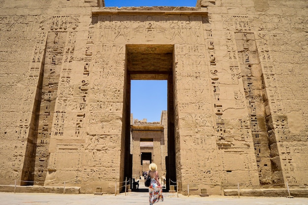 Photo gratuite gros plan d'une femme debout devant un temple de médinet habou en egypte