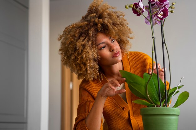 Gros plan sur une femme décorant sa maison avec des orchidées