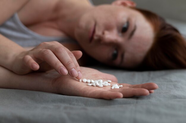 Gros plan femme déprimée tenant des pilules