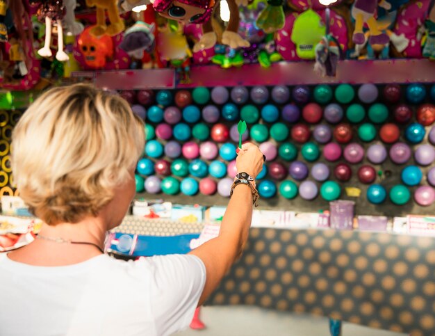 Gros plan, femme, éclater, ballons, vue postérieure