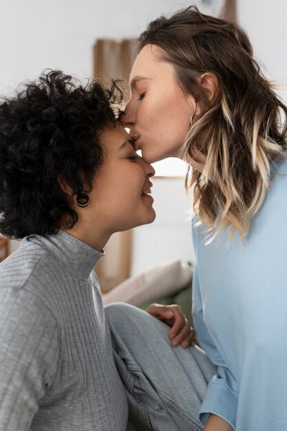 Gros plan femme embrassant sa petite amie sur le front
