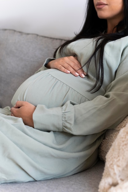 Gros plan femme enceinte assise sur le canapé