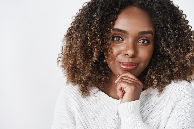 Gros plan d'une femme entrepreneur créative assurée et confiante souriante satisfaite tenant la main sur le menton dans une pose réfléchie ayant une idée intéressante