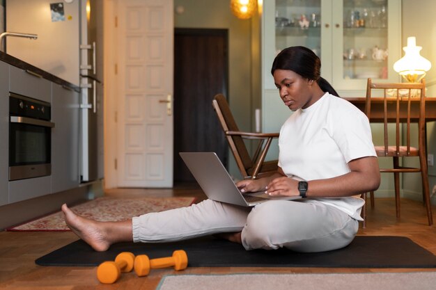 Gros plan sur une femme faisant de l'exercice après un instructeur en ligne