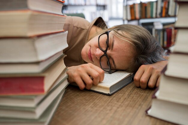 Gros plan femme fatiguée à la bibliothèque