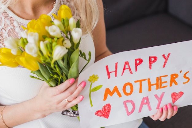 Photo gratuite gros plan de femme avec fleurs et affiche de la fête des mères