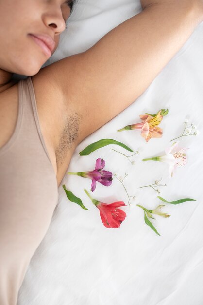 Gros plan sur une femme avec des fleurs autour de l'aisselle