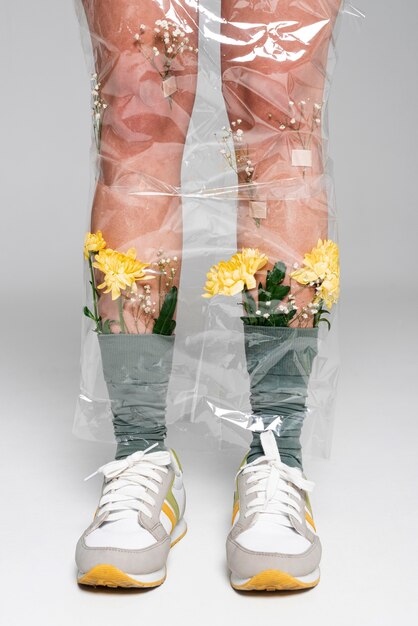 Gros plan femme avec des fleurs sur des chaussettes recouvertes de plastique