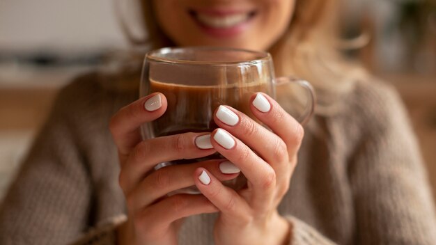 Gros plan femme floue tenant un verre