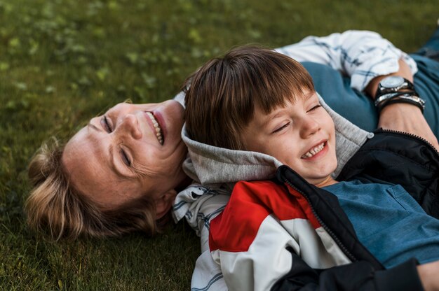 Gros plan femme heureuse et enfant sur l'herbe